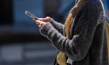 A pedestrian uses an Apple iPhone in San Francisco on July 28.