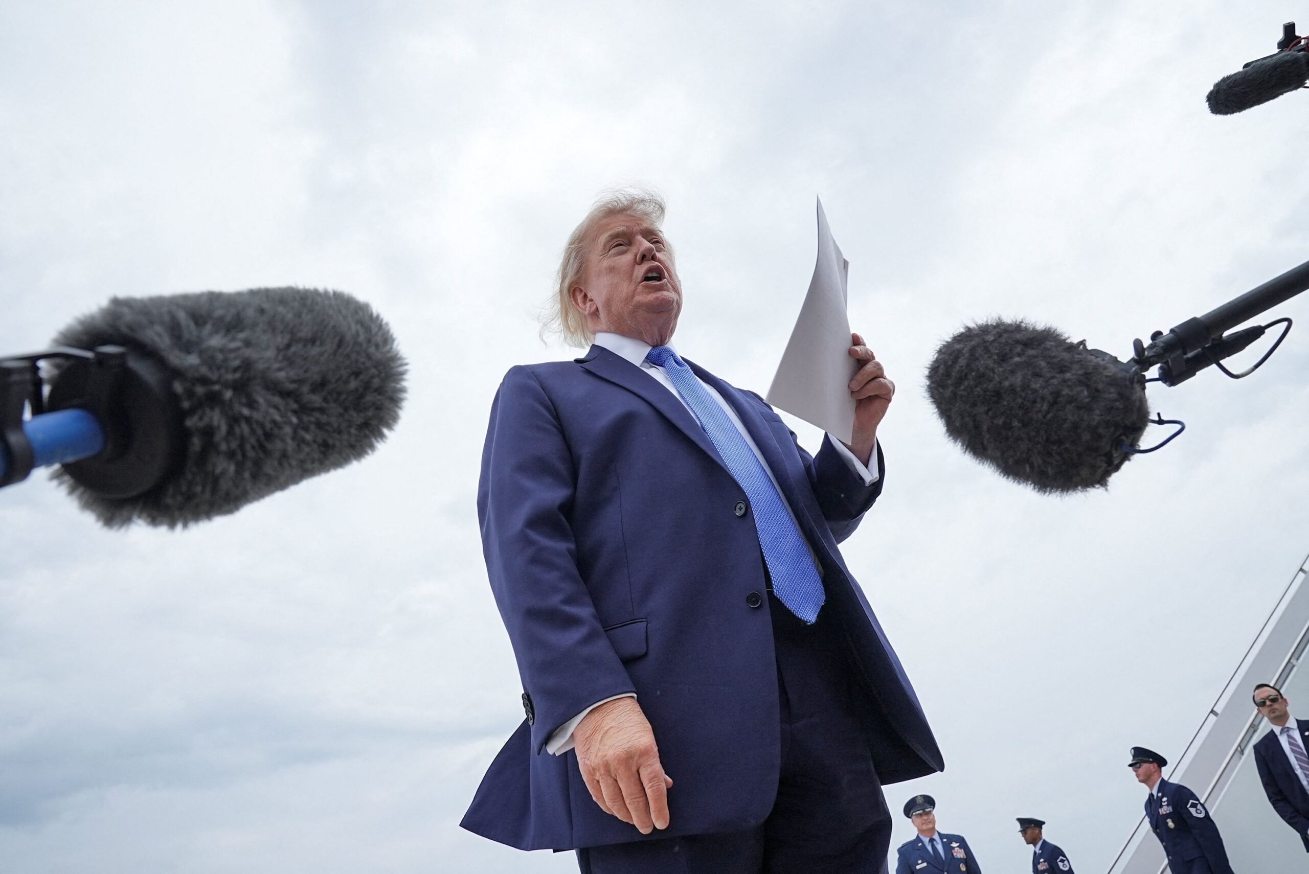<i>Ken Cedeno/Reuters via CNN Newsource</i><br/>US President Donald Trump holds a printed-out article as he speaks to the members of the media after disembarking Marine One