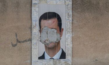 A defaced portrait of Syria's ousted president Bashar al-Assad hangs on a wall in the capital Damascus on June 2