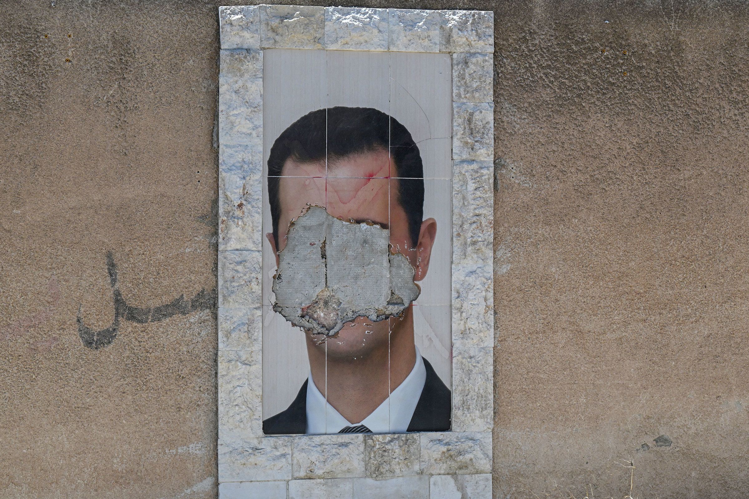 <i>Louai Beshara/AFP/Getty Images via CNN Newsource</i><br/>A defaced portrait of Syria's ousted president Bashar al-Assad hangs on a wall in the capital Damascus on June 2