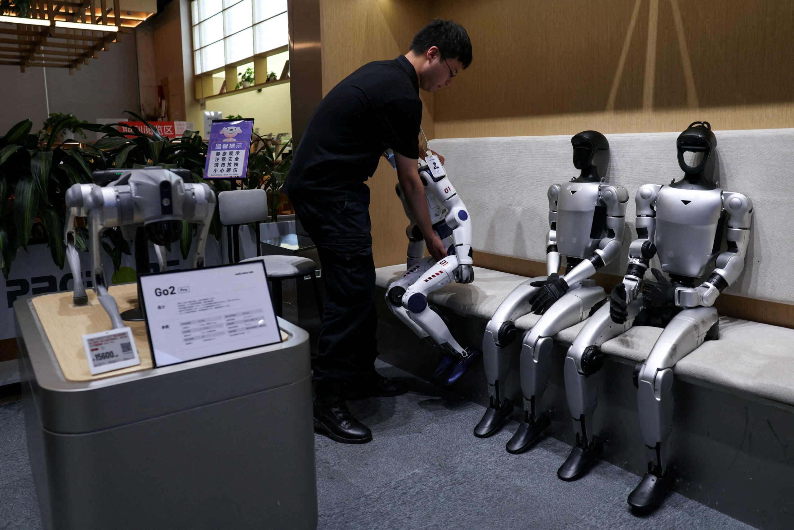 <i>Tingshu Wang/Reuters via CNN Newsource</i><br/>A staff member places a Unitree's R1 humanoid robot back in its seat at a Unitree store in Beijing