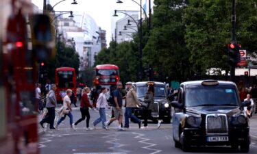 Pedestrians walk as traffic drives along Oxford Street in London