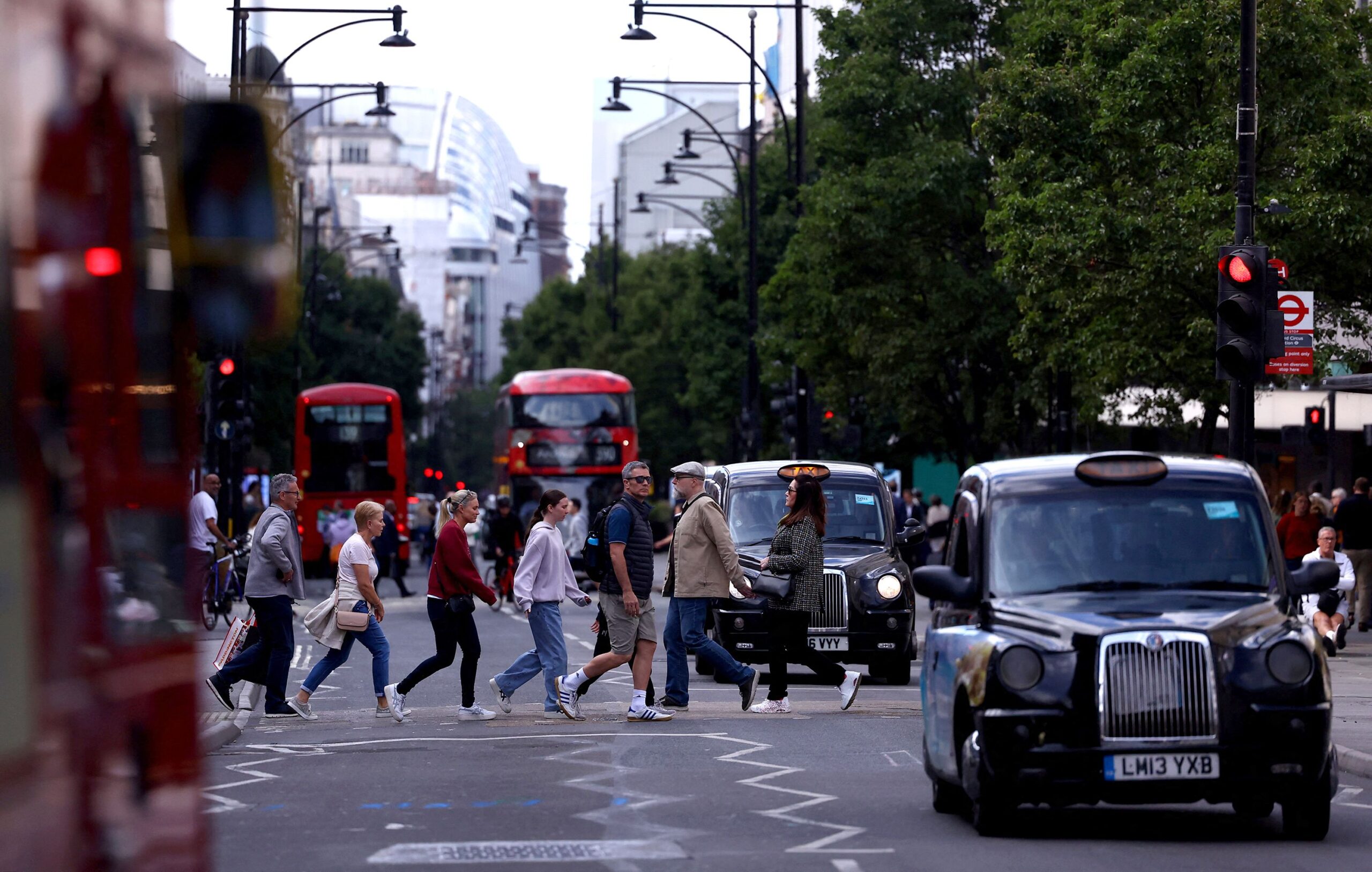 <i>Hannah McKay/Reuters via CNN Newsource</i><br/>Pedestrians walk as traffic drives along Oxford Street in London