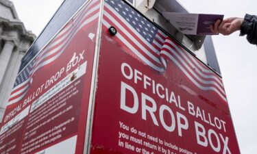 A voter drops their ballot at an official ballot drop box outside City Hall during a primary election in San Francisco