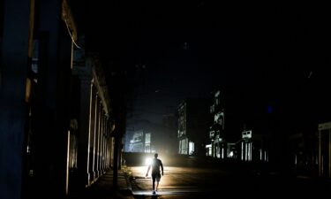 A man walks down a dark street as Cuba's electricity grid collapsed late on Sunday