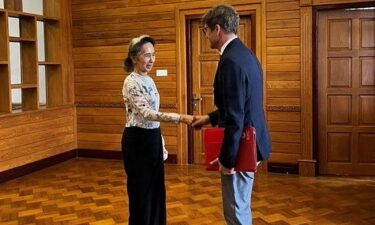 Myanmar's detained former leader Aung San Suu Kyi shakes hands with Myanmar's Resident Representative and Head of Delegation for the International Committee of the Red Cross (ICRC) Arnaude de Baecque