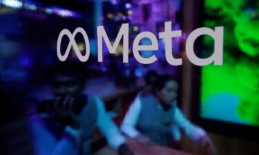 People are seen behind a logo of Meta Platforms