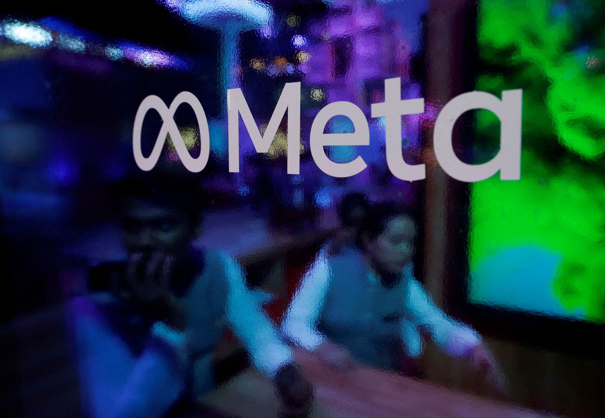 <i>Francis Mascarenhas/Reuters/File via CNN Newsource</i><br/>People are seen behind a logo of Meta Platforms