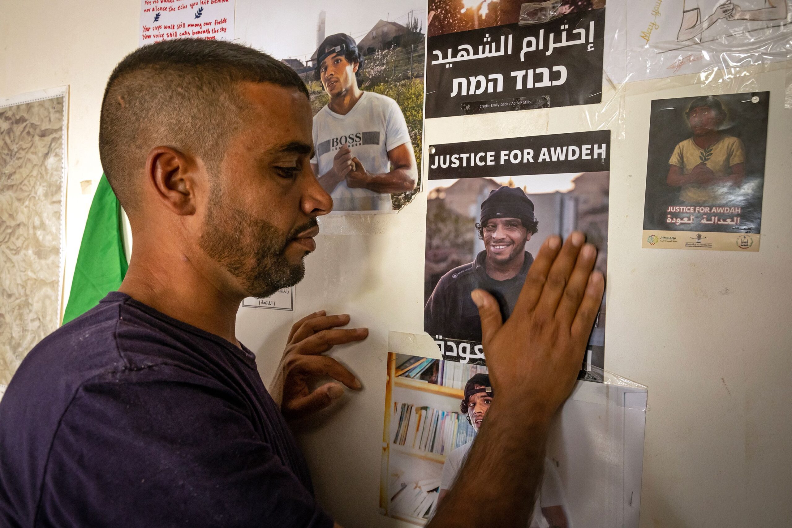 <i>Fadel Senna/AFP/Getty Images via CNN Newsource</i><br/>The brother of slain Palestinian activist Odeh Hathalin touches a poster calling for accountability following his killing in the occupied West Bank last year.