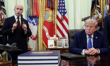 White House deputy chief of staff Stephen Miller speaks while President Donald Trump listens during an event to sign executive orders in the Oval Office of the White House