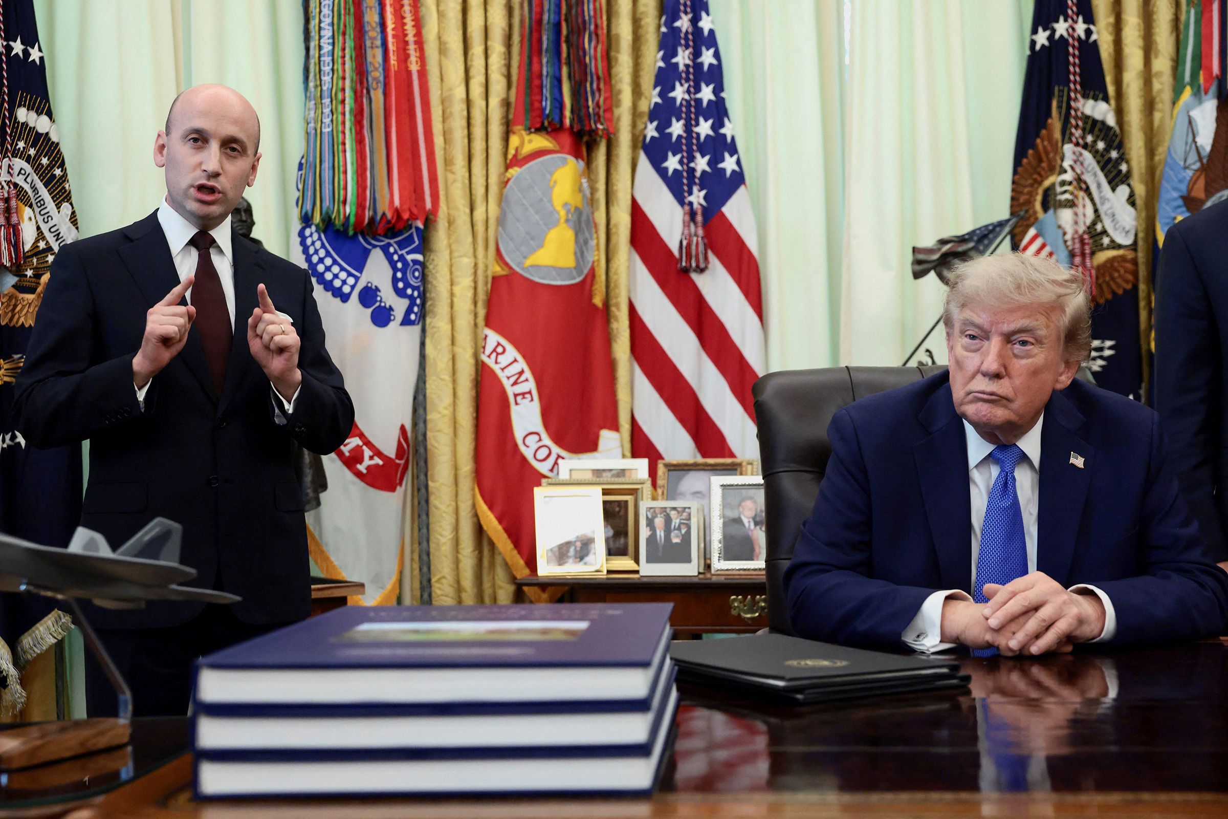 <i>Evelyn Hockstein/Reuters via CNN Newsource</i><br/>White House deputy chief of staff Stephen Miller speaks while President Donald Trump listens during an event to sign executive orders in the Oval Office of the White House