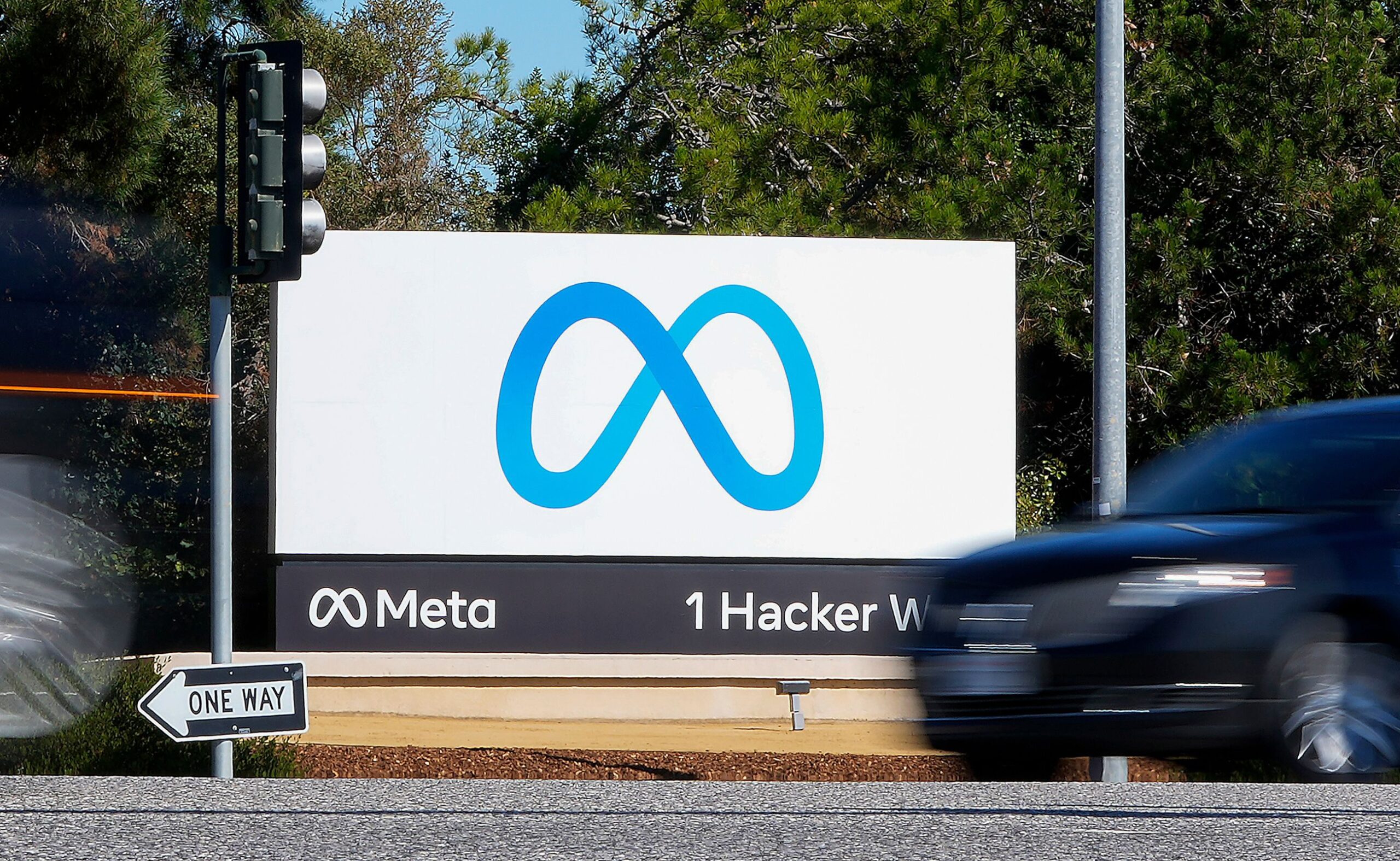 <i>Tony Avelar/AP/File via CNN Newsource</i><br/>A car passes a sign with a Meta logo at the company headquarters in Menlo Park