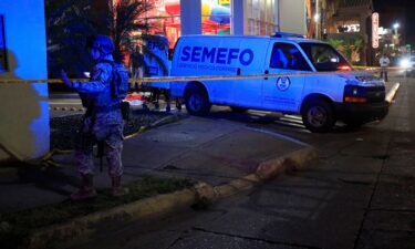 A soldier stands guard as forensic technicians and police officers work at the crime scene where Mexican social media influencer Cesar Gastelum
