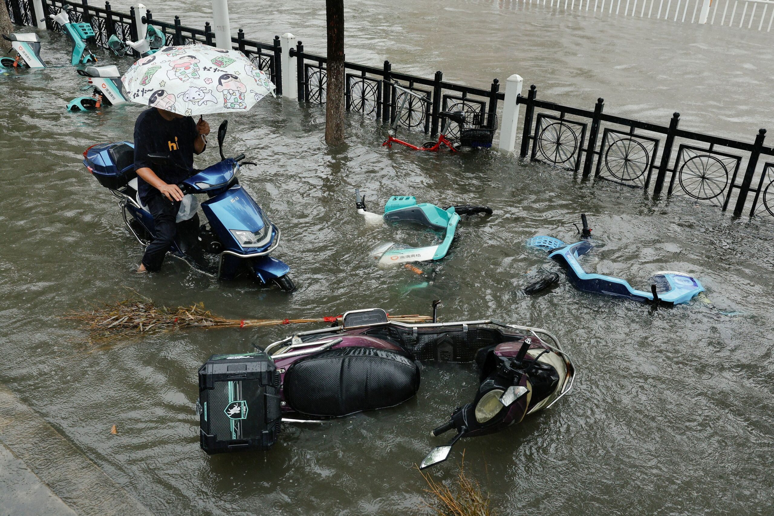 <i>Go Nakamura/Reuters via CNN Newsource</i><br/>A flooded street is filled with fallen scooters during heavy rain brought by Typhoon Dolphin after it weakened into a tropical storm