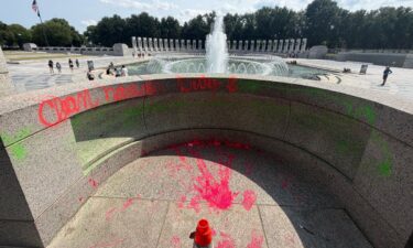 Graffiti reading “Clean hands dirty $” is visible in the World War II Memorial in Washington