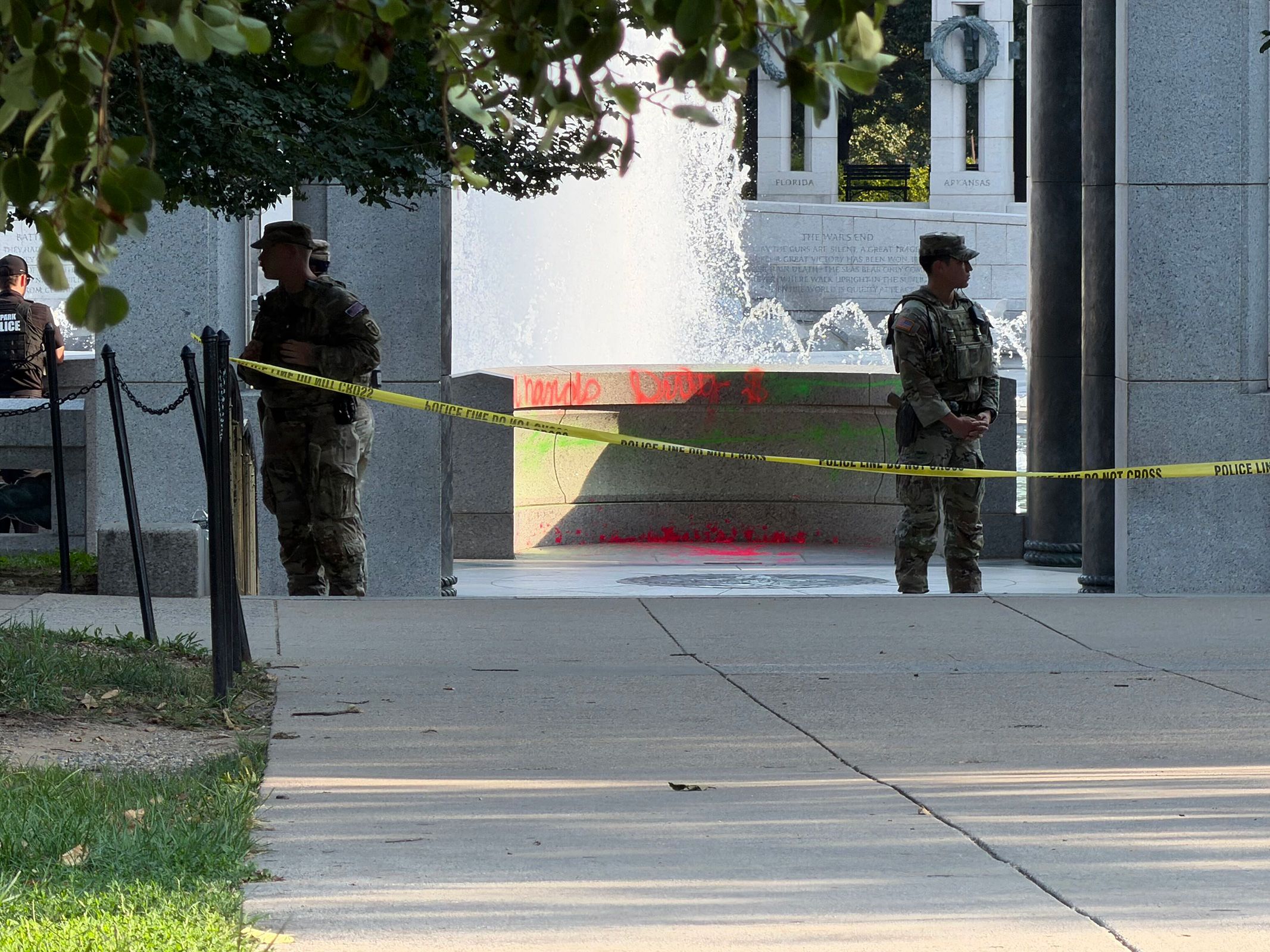 <i>Steve Williams/CNN via CNN Newsource</i><br/>Members of the National Guard are visible near where graffiti was painted onto the World War II Memorial in Washington