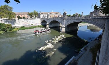 A tourist boat passes near an Ancient Roman bridge emerging from the Tiber river in central Rome on August 13.