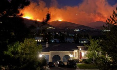 Photos from the Truckee Meadows Fire Protection District shows flames in the distance progressing towards residential areas in Reno