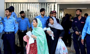 A worker removes broken pieces of a glass window after a fire broke out at the Pakistan Institute of Medical Sciences (PIMS) hospital in Islamabad