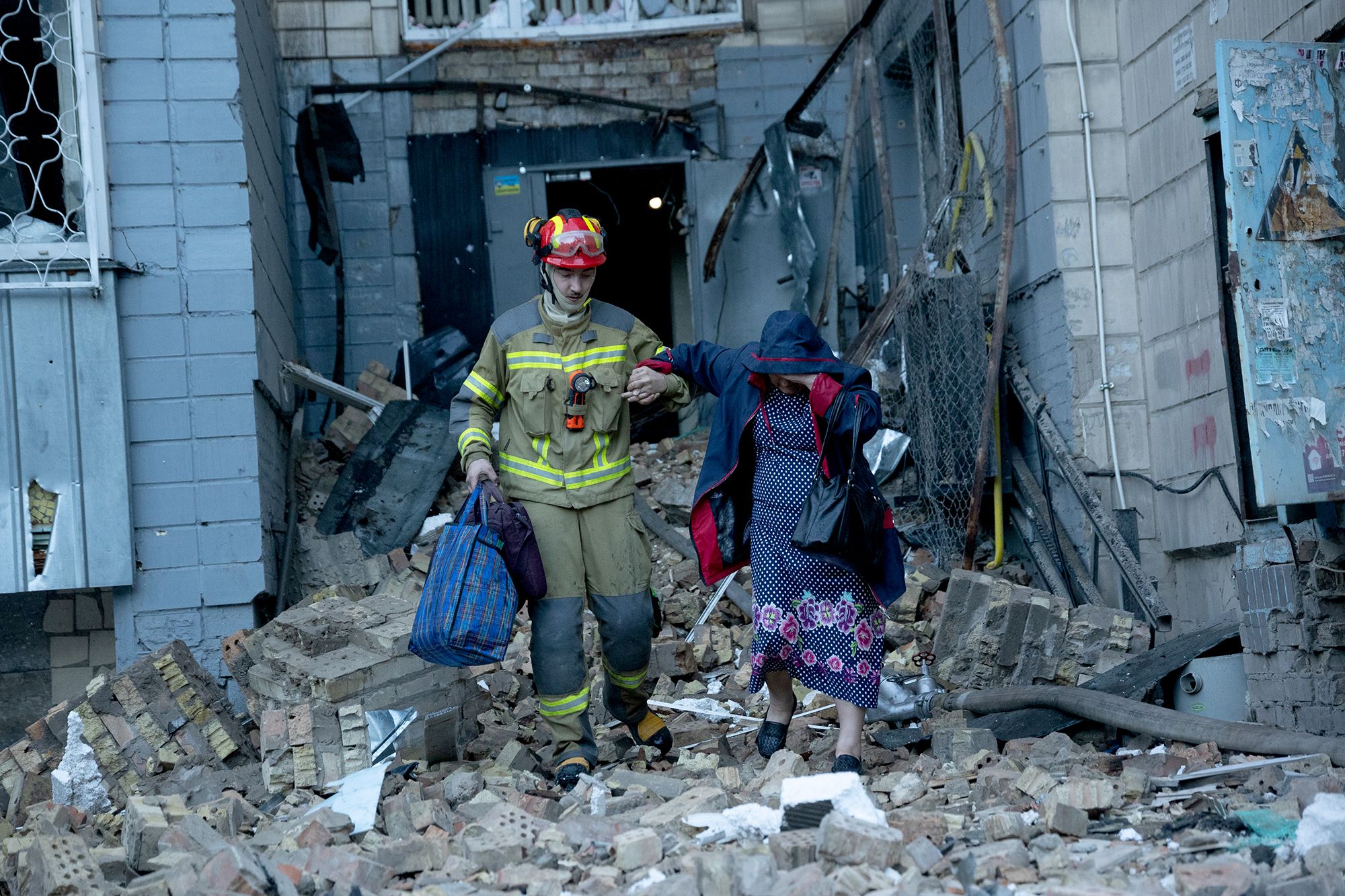 <i>Oleksandr Magula/Global Images Ukraine/Getty Images via CNN Newsource</i><br/>A rescuer helps a woman through the rubble after an apartment was damaged by a Russian strike in Kyiv on Thursday.