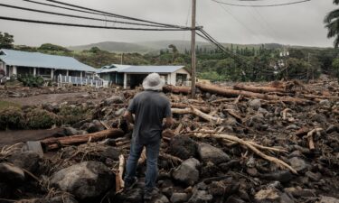 A man watches debris flow along Ka'alaiki Road after Hurricane Lala in Naalehu