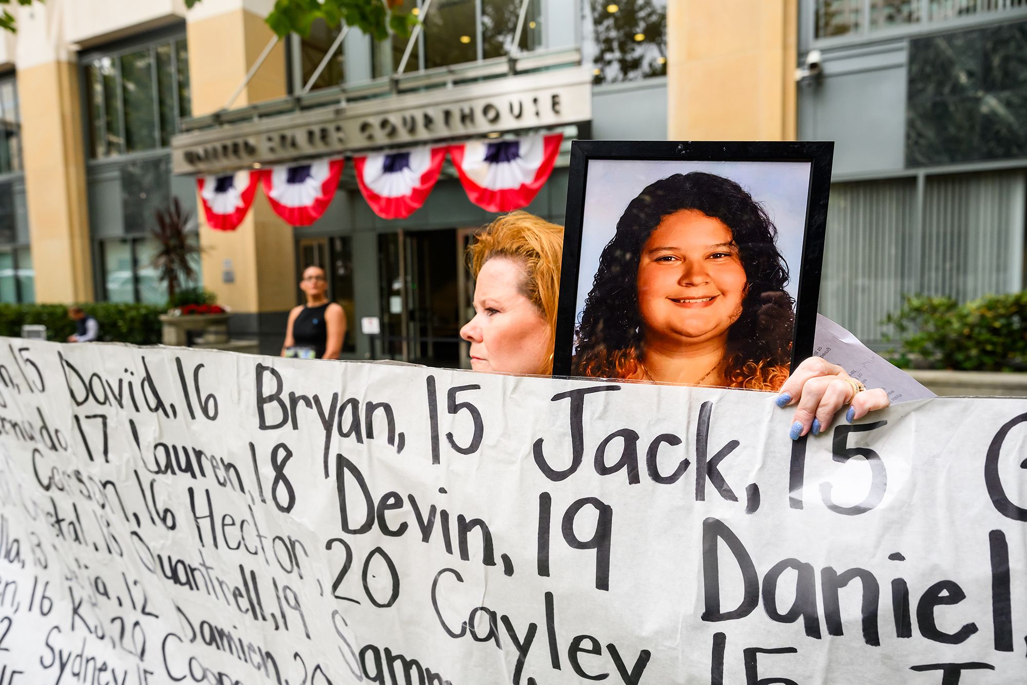<i>Noah Berger/AP via CNN Newsource</i><br/>Erin Popolo holds a picture of daughter Emily Murilla