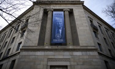 A a new banner featuring an image of President Donald Trump is displayed on the facade of the US Department of Justice headquarters