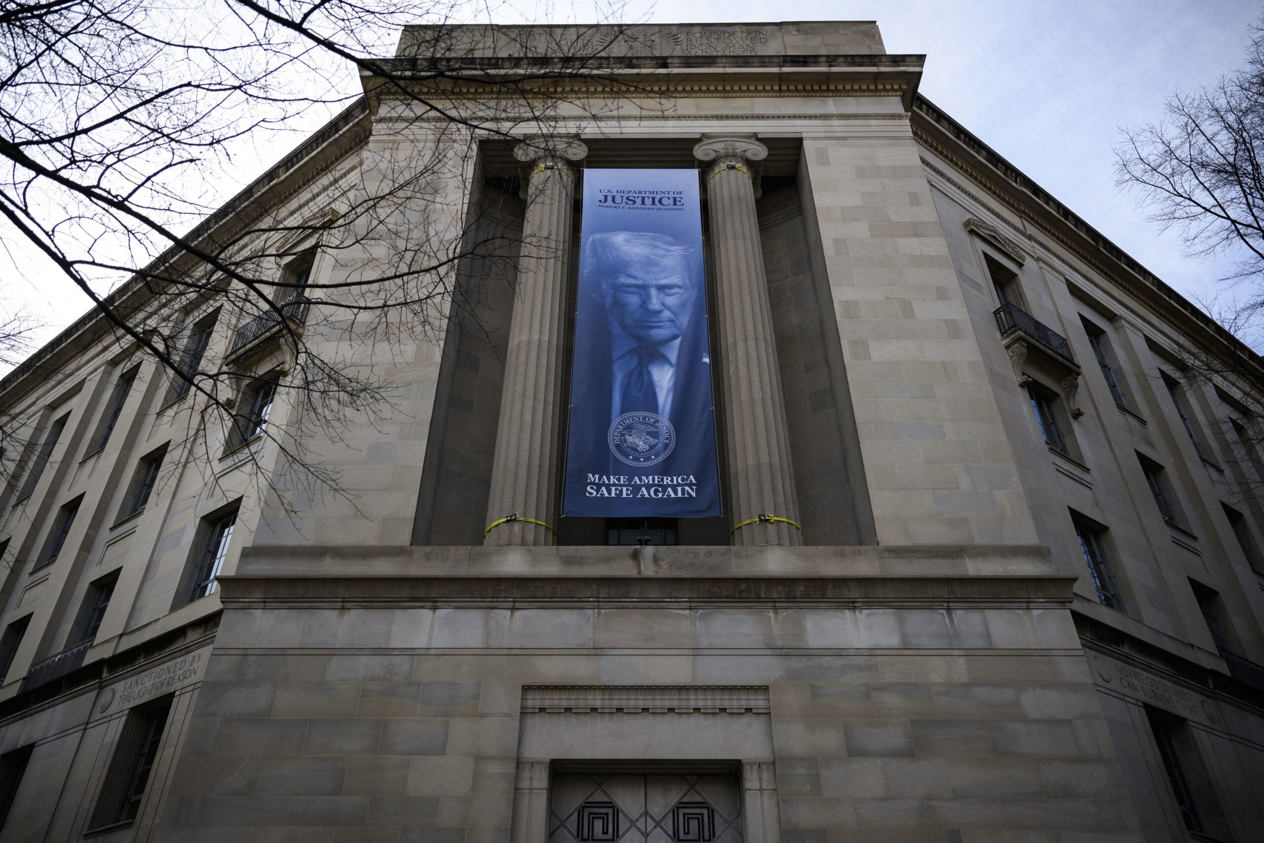 <i>Drew Angerer/AFP/Getty Images via CNN Newsource</i><br/>A a new banner featuring an image of President Donald Trump is displayed on the facade of the US Department of Justice headquarters