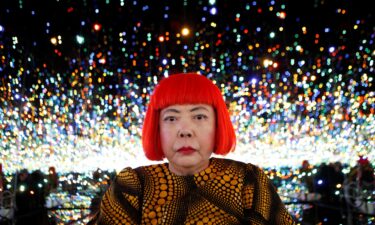Japanese artist Yayoi Kusama poses for a photograph inside her Infinity Mirrored Room installation titled "The Souls of Millions of Light Years Away" during a media preview of her new exhibition at the David Zwirner gallery in New York November 7