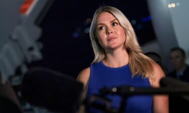 White House Press Secretary Karoline Leavitt looks on as President Donald Trump speaks to reporters after stepping off Air Force One on August 11