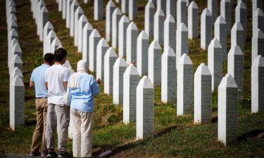 Visitors stand at the memorial cemetery in the village of Potocari
