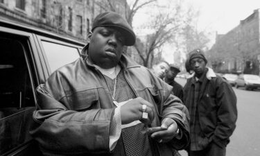 Notorious B.I.G. poses for a photo outside his mother's house in Brooklyn in 1995.
