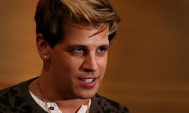 Milo Yiannopoulos reacts during a press conference on arrival at the Sydney International Airport on November 29