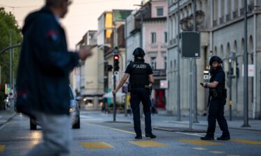 Police officers patrol a street following a shooting at a rave in downtown Aarau
