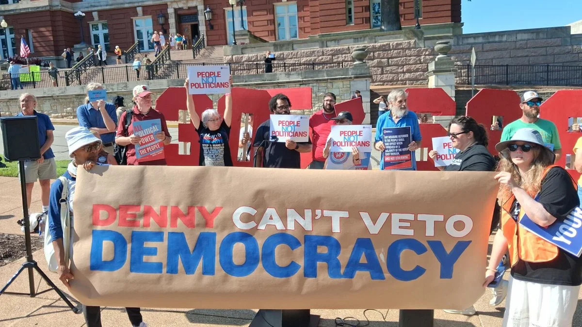 Members of political action group People Not Politicians hold a sign addressing Secretary of State Denny Hoskins outside the Missouri Supreme Court building on Tuesday, Sept. 2, 2026.