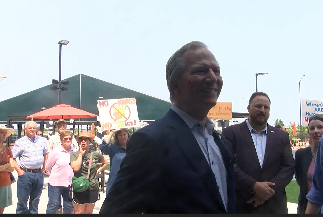 Rep. Bob Onder answers questions from the media in front of protestors in Columbia in May 2025.