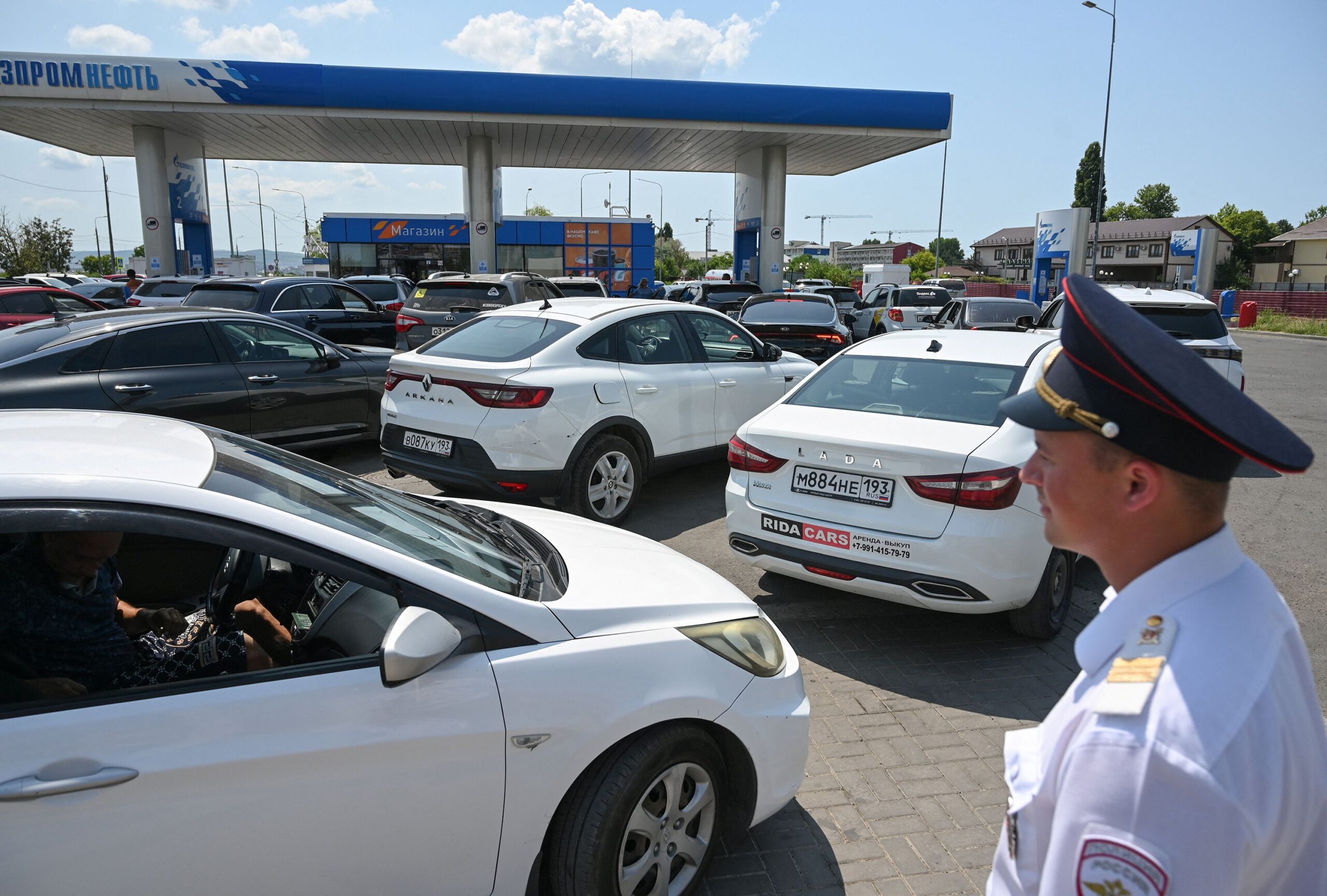 <i>Sergey Pivovarov/Reuters via CNN Newsource</i><br/>A Cossack keeps order in a line at a gas station resulting from fuel shortages following Ukrainian attacks on oil refineries
