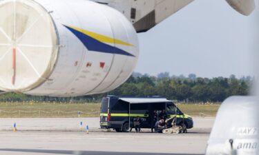 Police officers pictured searching a field at the Leipzig/Halle Airport for evidence.