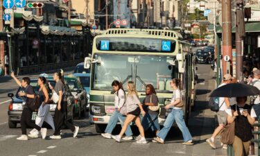 A tourist group crosses the street near the Yasaka Shrine in Osaka.