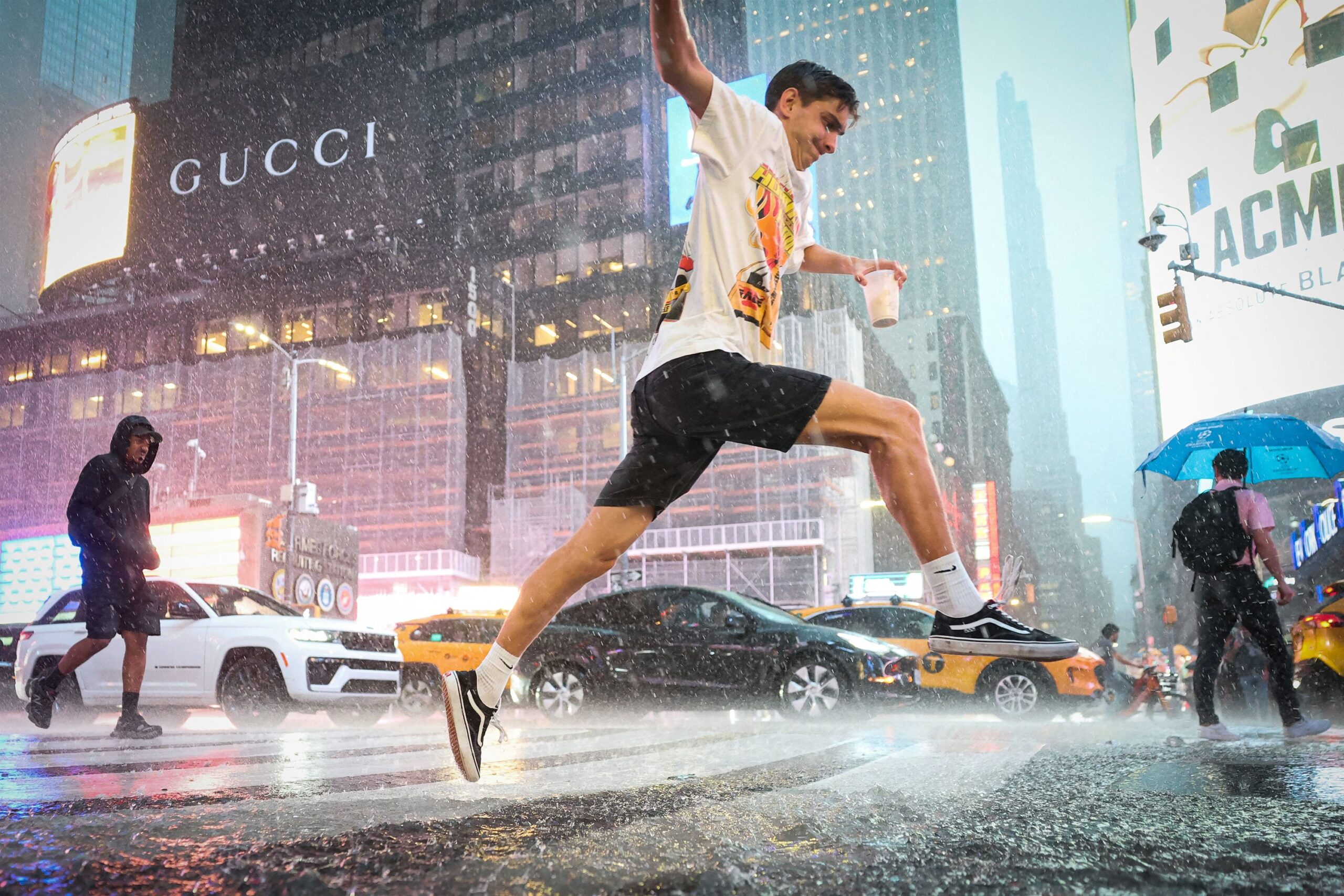 <i>Brendan McDermid/Reuters via CNN Newsource</i><br/>A man jumps over water in Times Square during a severe rain storm in New York on August 20.