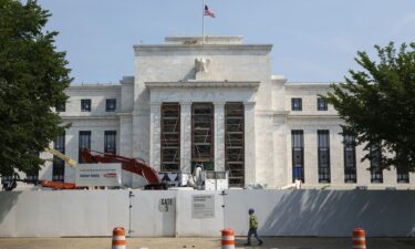 A construction worker walks by the Federal Reserve Building in Washington
