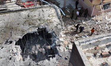 People inspect damage and debris at a building that Iranian media said was hit by a US strike while a wedding celebration was taking place there