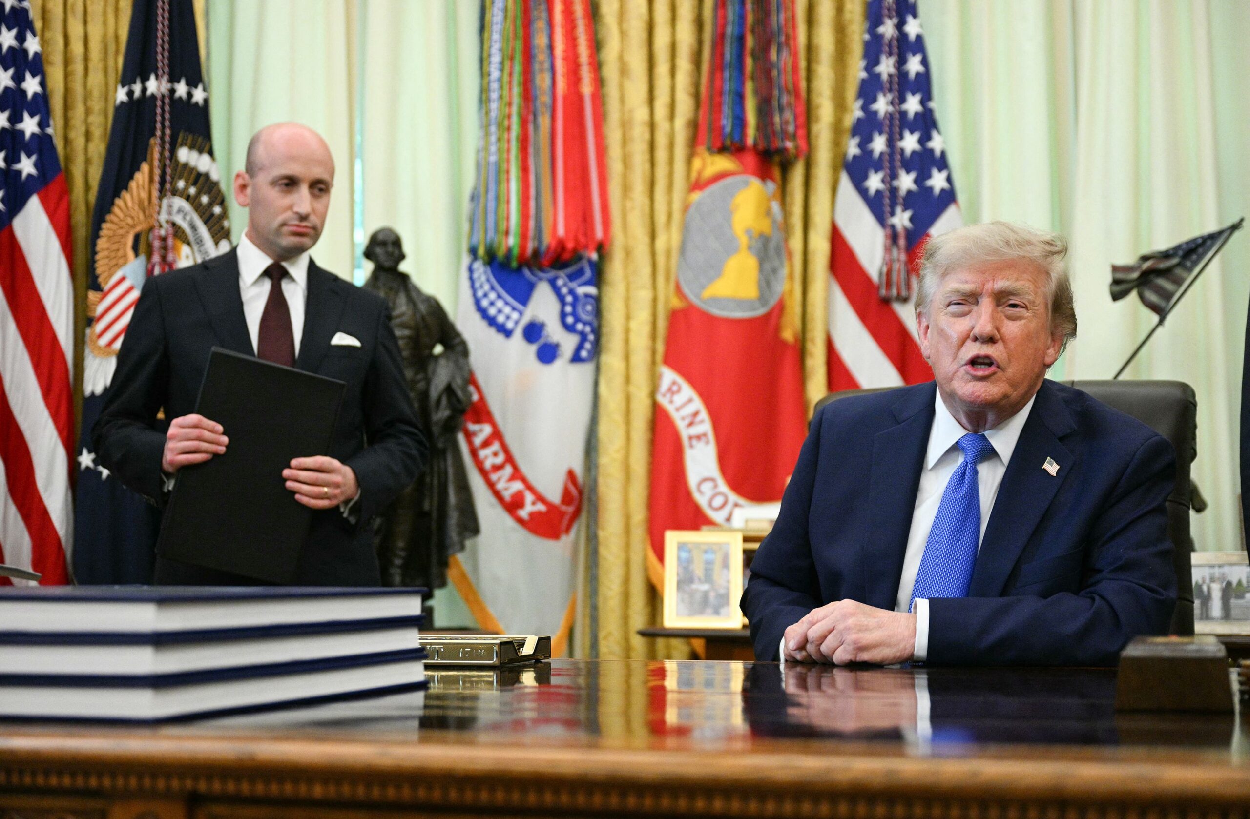<i>Jim Watson/AFP/Getty Images via CNN Newsource</i><br/>White House Deputy Chief of Staff Stephen Miller (L) holds an executive order on birthright citizenship as US President Donald Trump speaks before signing it in the Oval Office of the White House in Washington
