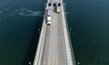 This aerial view shows trucks passing over the Peace Bridge between Canada and the US in Fort Erie