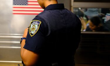 A New York Police Department officer patrols on a subway platform in New York in August 2025.