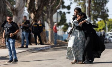 Two women react as they leave a reunification center following the shooting at the Islamic Center of San Diego in southern California