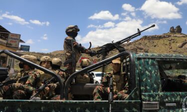 Houthi fighters escort a convoy carrying prisoners freed in Mokha through the Bani Matar district on its way to Sanaa