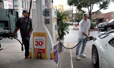 Customers purchase gas at a station on September 15