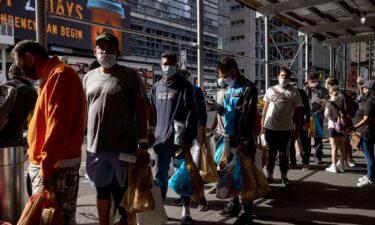 A group of migrants wait in line after arriving from Texas
