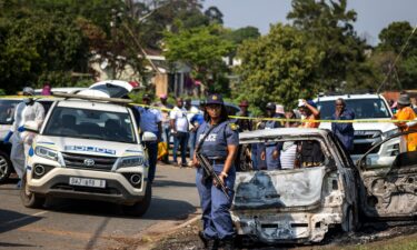 A police officer stands at the scene of a mass shooting at a house party in KwaMakhutha township south of the city of Durban